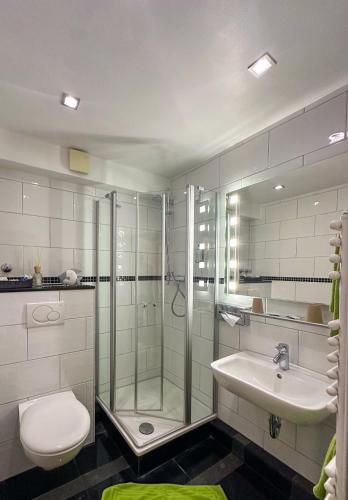 a bathroom with a shower and a toilet and a sink at Hotel Am Sportpark in Duisburg