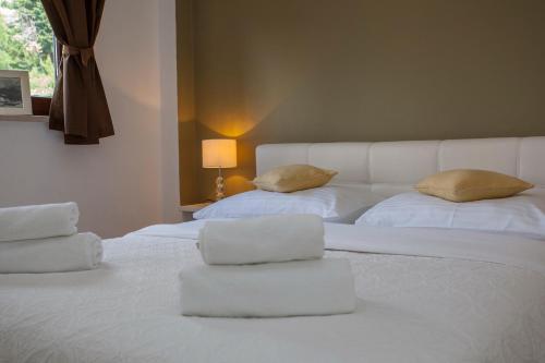 two beds with white sheets and pillows in a room at Villa Makarana Apartments in Makarska