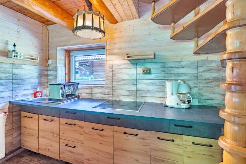 a kitchen with wooden cabinets and a counter top at Resort 7 Crai - Cabana Calinet in Zărneşti