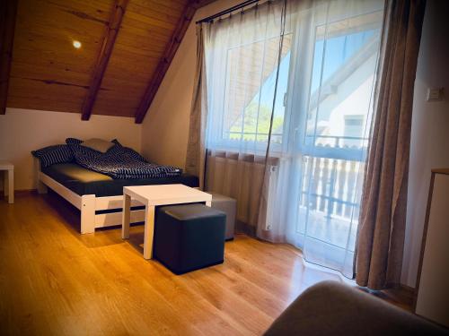 a room with a bed and a table and a window at Zielone Roztocze in Susiec
