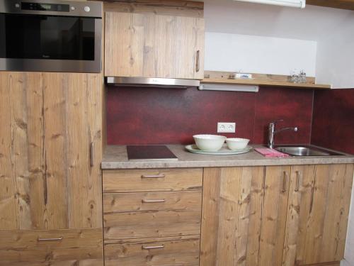 a kitchen with wooden cabinets and a sink at Gästehaus Bergstüberl in Reit im Winkl