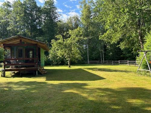 a gazebo in the middle of a grass field at Forest Camping in Lõupõllu