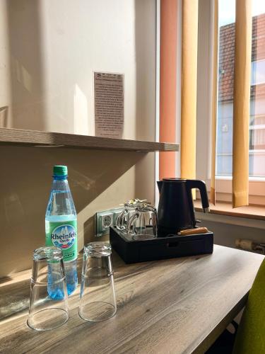 a bottle of water and two glasses on a table at Hotel Am Sportpark in Duisburg