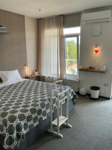 a bedroom with a large bed and a window at Гостевой дом SUN TAG in Chornomors'ke