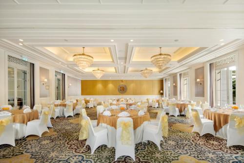 a banquet hall with tables and chairs and chandeliers at Rumah Luwih Bali in Keramas
