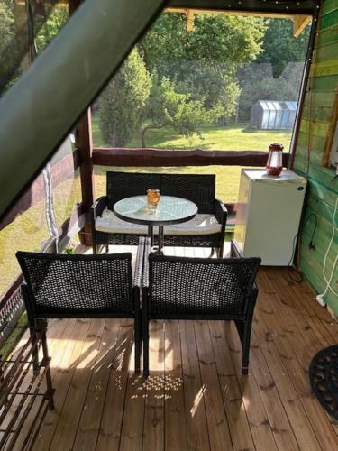 a patio with a table and chairs on a deck at Forest Camping in Lõupõllu