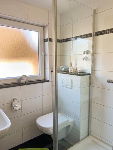 a bathroom with a toilet and a glass shower at Hotel Am Sportpark in Duisburg