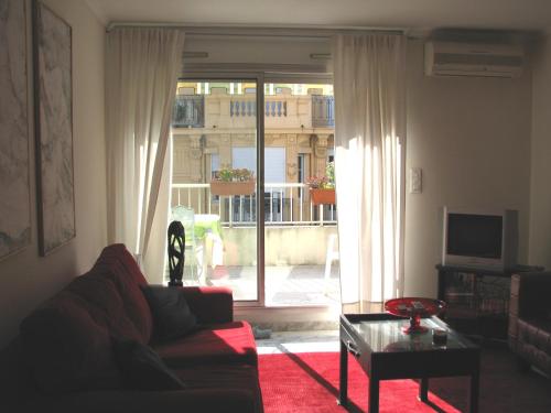 a living room with a couch and a large window at Appartamento Sole in Nice