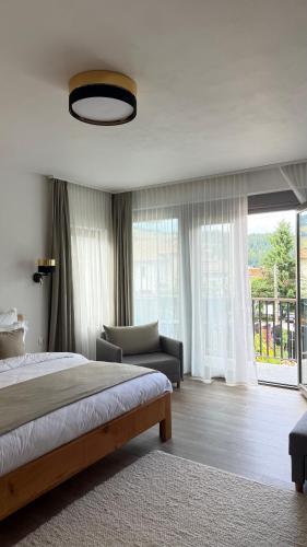 a bedroom with a bed and a couch and a window at REY Chalet in Vatra Dornei