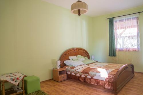 a bedroom with a bed and a table and a window at Tisza-Tavirózsa Vendégház in Tiszaszőlős