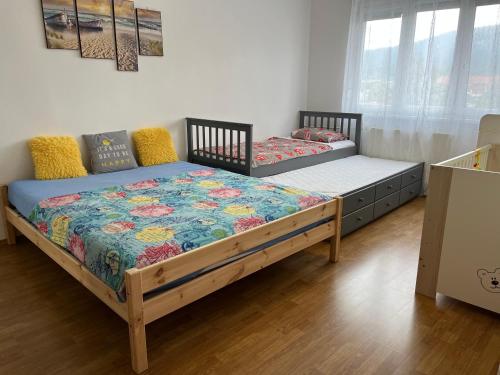 two twin beds in a room with wooden floors at Rodinný 2 izbový apartmán v centre in Martin
