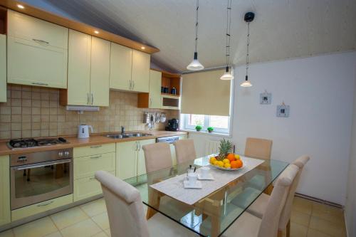 a kitchen with a glass table with a bowl of fruit on it at Villa Makarana Apartments in Makarska