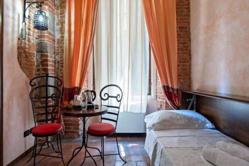 a bedroom with a bed and a table and chairs at Antica Corte dei Principi Charming Rooms in Lucca