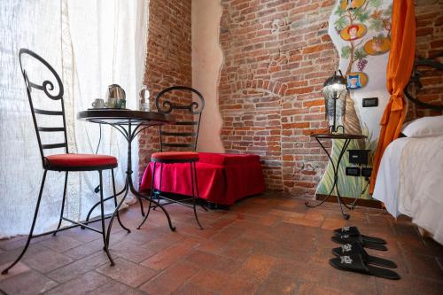 a room with a table and chairs and a brick wall at Antica Corte dei Principi Charming Rooms in Lucca