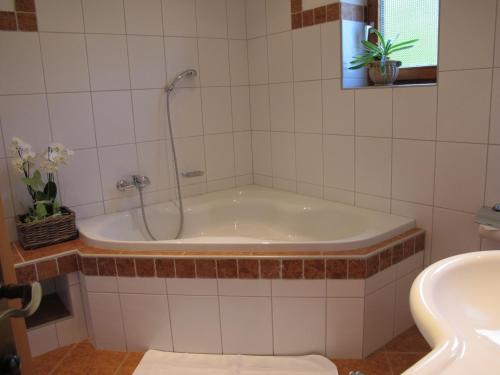 a bath tub with a shower in a bathroom at Gästehaus Bergstüberl in Reit im Winkl