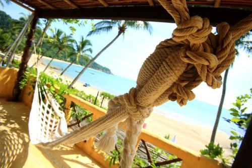 a view of the beach from a hammock on a beach at Vacation Village Phra Nang Lanta - SHA Extra Plus in Ko Lanta