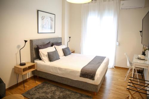 a bedroom with a large bed and a window at KK Athens Fine Stay-Steps to Metro-Modern & Cozy Apartments in Athens