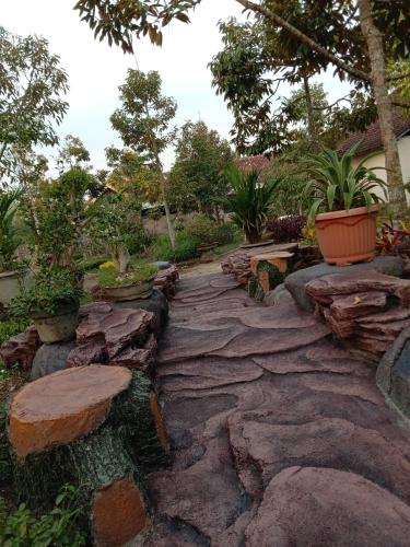 a stone walkway in a garden with rocks and trees at 361 Alam in Rarang