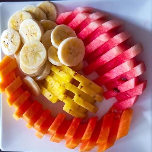 een bord groenten en fruit op een bord bij White Moon Cabin & Cottage in Ella