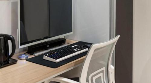 a desk with a computer monitor and a keyboard at Seven Motel Ansan in Ansan