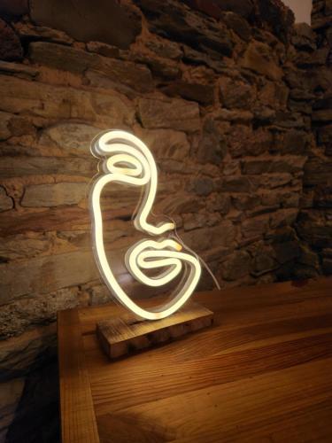 a lit up light up snake lamp on a table at le cocon d'amour " le fournil avec bain nordique privé " in La Chapelle-du-Fest