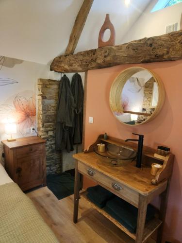 a bathroom with a sink and a mirror at le cocon d'amour " le fournil avec bain nordique privé " in La Chapelle-du-Fest