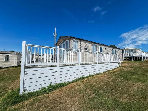 a white fence in front of a house at Modern Caravan With Decking At Valley Farm, Essex Ref 46112V in Great Clacton