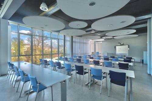 a conference room with tables and chairs and windows at Hotel Veba in Broumov