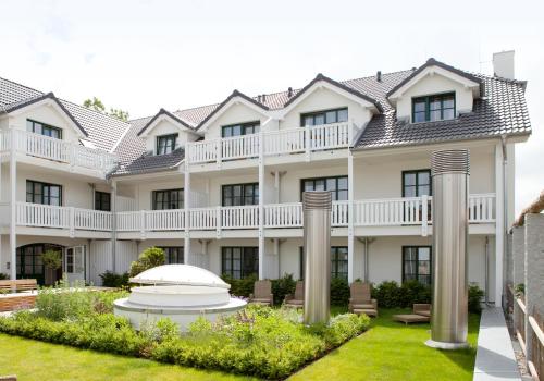 an exterior view of a large white building at Fuchsbau Romantik Hotel & SPA Restaurant & FOX Bar in Timmendorfer Strand