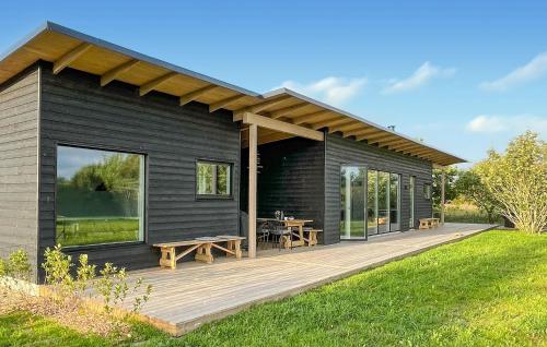 a black house with a deck with a picnic table at Gorgeous Home In Tarm With Sauna in Tarm