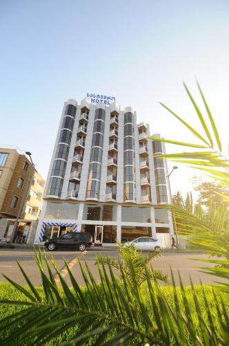 un edificio de hotel con un coche aparcado delante de él en Hotel ''Premium Palace'' en Batumi