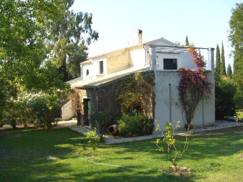 a small house in a yard with a green lawn at Alexandra villas in Gouvia