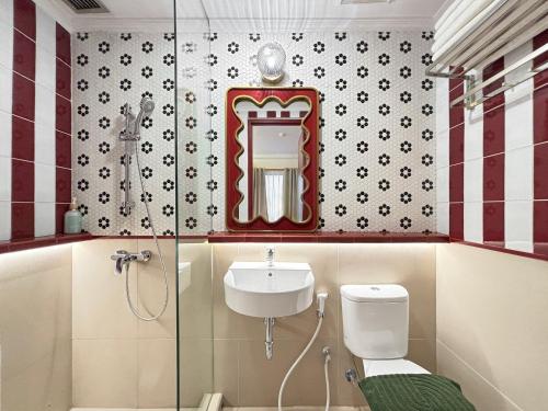 a bathroom with a sink and a toilet and a mirror at youre at - The Majesty Apartment in Bandung