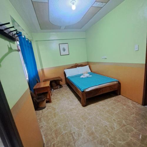 a bedroom with a bed with a stuffed animal on it at Baguio Tourist Cabin in Baguio