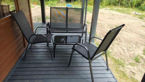 three chairs and a table on a porch at Amber Coast domek nr 2 in Jantar