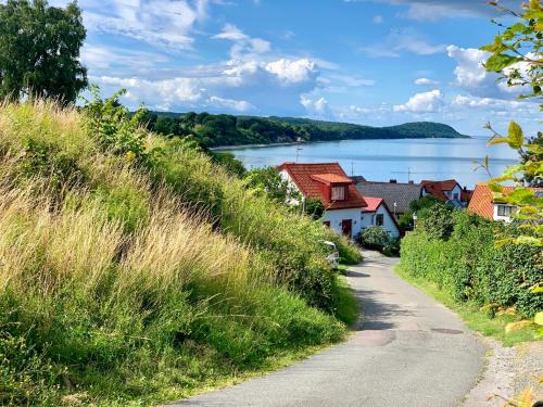 a road leading down to a village with a lake at Villa Österlen på Viks fiskeläge in Simrishamn