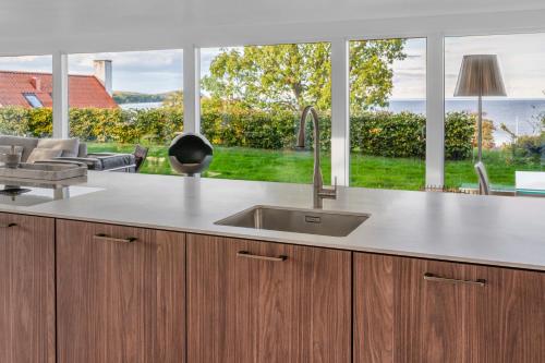 a kitchen with a sink and a large window at Villa Österlen på Viks fiskeläge in Simrishamn