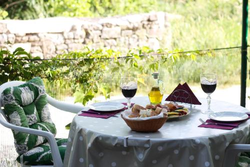 una mesa con un plato de comida y dos copas de vino en Apartments Lavel, en Trogir