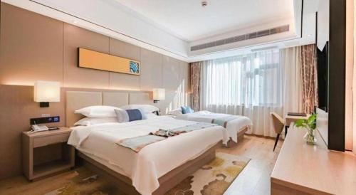 a hotel room with two beds and a window at GreenTree Eastern Dali Railway Station Hotel in Dali