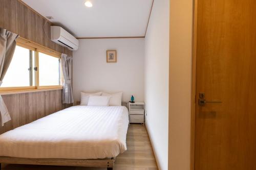 a small bedroom with a bed and a window at 軽井沢フォーシーズホテル in Karuizawa