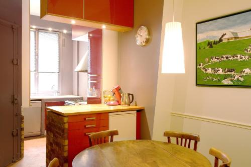une cuisine avec une table et une cuisine avec une table et des chaises dans l'établissement Le85 Paris, à Paris