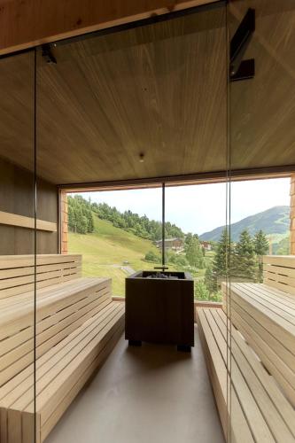 a room with a large window and a table at Hotel Marten - Ski-In & Ski-Out in Saalbach Hinterglemm