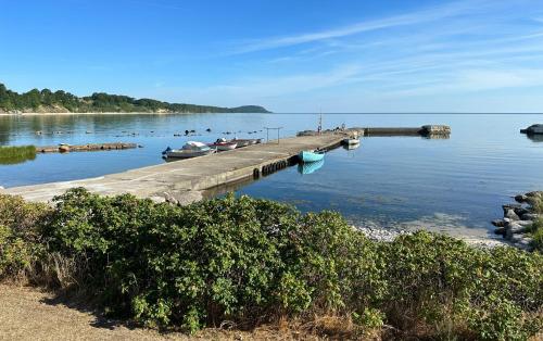 a dock with two boats in the water at Villa Österlen på Viks fiskeläge in Simrishamn