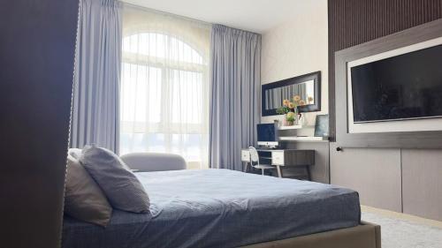 una camera da letto con un letto, una tv e una finestra di Peace Room opp Ajman City Center 1BHK ad Ajman