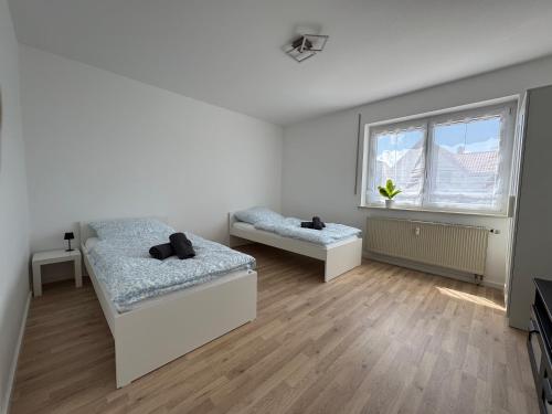 BiberbachにあるWundP Living Wohnung mit Terrasse Parkplatzのベッドが2つと窓がある白い部屋