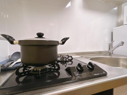東京にある池袋アンプリルHouse1F 2bedrooms suite Cozy for 1-4 guestsのキッチンのコンロの上の鍋