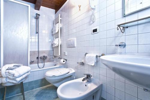 a white bathroom with a sink and a toilet at Ca' San Polo - Ferretti Hotels Collection in Venice