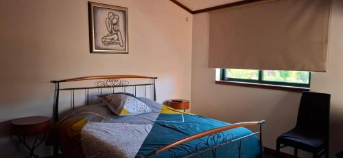 una camera da letto con un letto, una sedia e una finestra di Villa do Lago a Vibeira