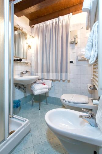 a bathroom with two sinks and two toilets at Ca' San Polo - Ferretti Hotels Collection in Venice