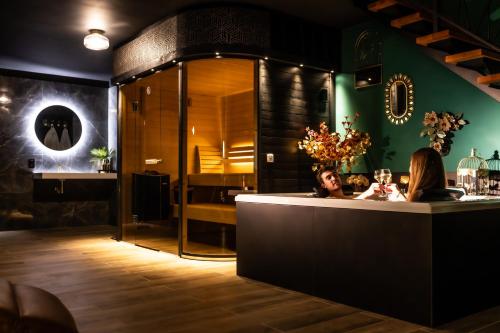 a couple sitting at a bar in a restaurant at L'espace d'un moment - La chambre in Thuin